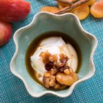 Fruit compote sits atop of creamy yoghurt in a light blue bowl.