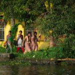 Local women walk along the verdant paths of the Kerala Backwaters.