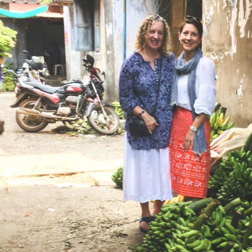 Pauli-Ann and Karen standing near bananas in Kozhikode (Calicut)