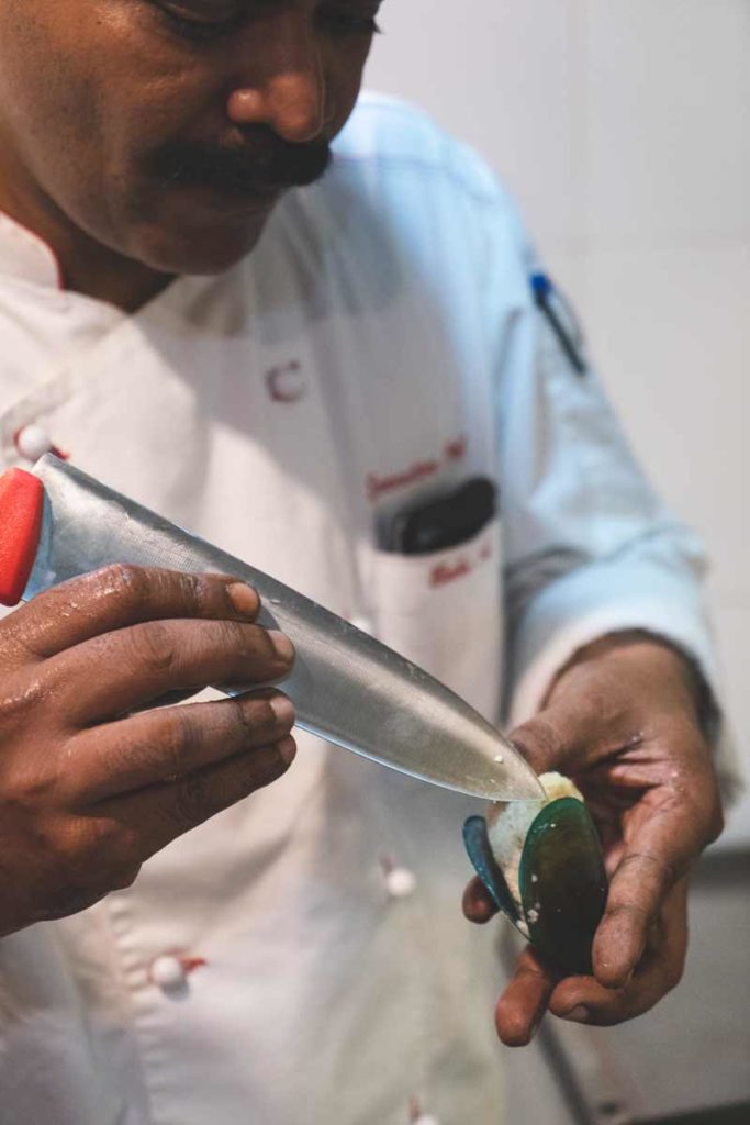 Chef prepares Arikkadukka with a sharp knife.