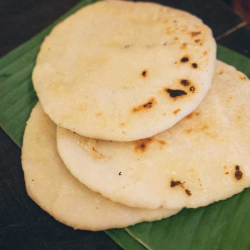 Three grilled pathiri bread sitting on a green banana leaf