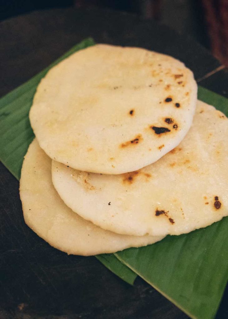 Three grilled pathiri bread sitting on a green banana leaf