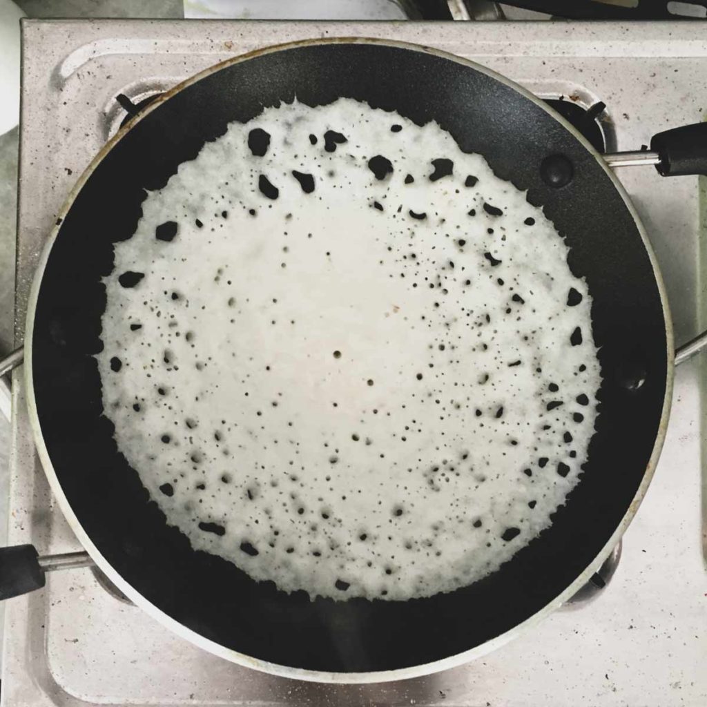 Appam cooking in a pan