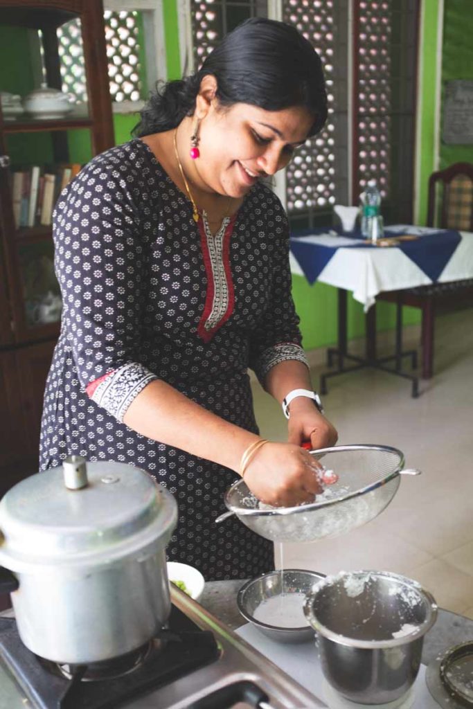 Aroma Dipu squeezes raw coconut for milk