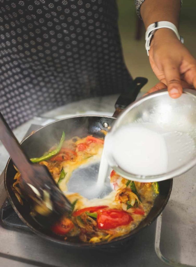 Coconut milk poured into fish moilee