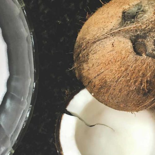 Split coconut and a bowl of coconut milk