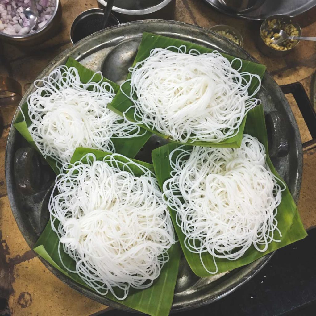 string hoppers sit on banana leaves