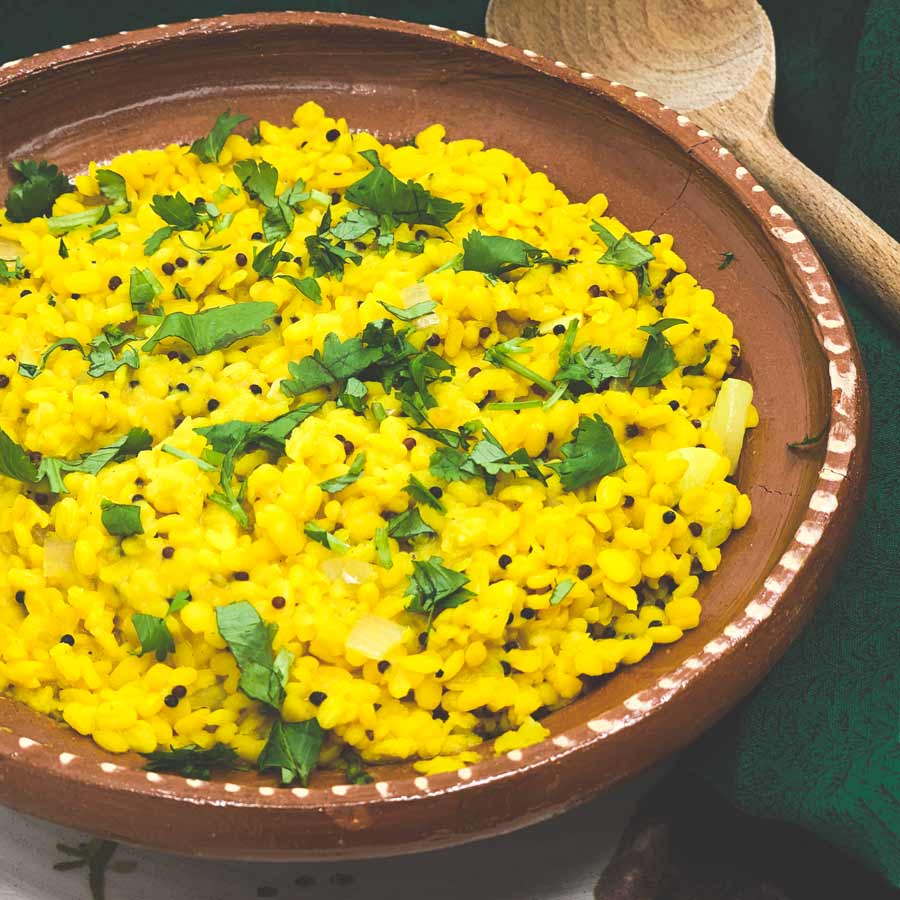 Yellow Moong Dal Curry sits in a round clay bowl.