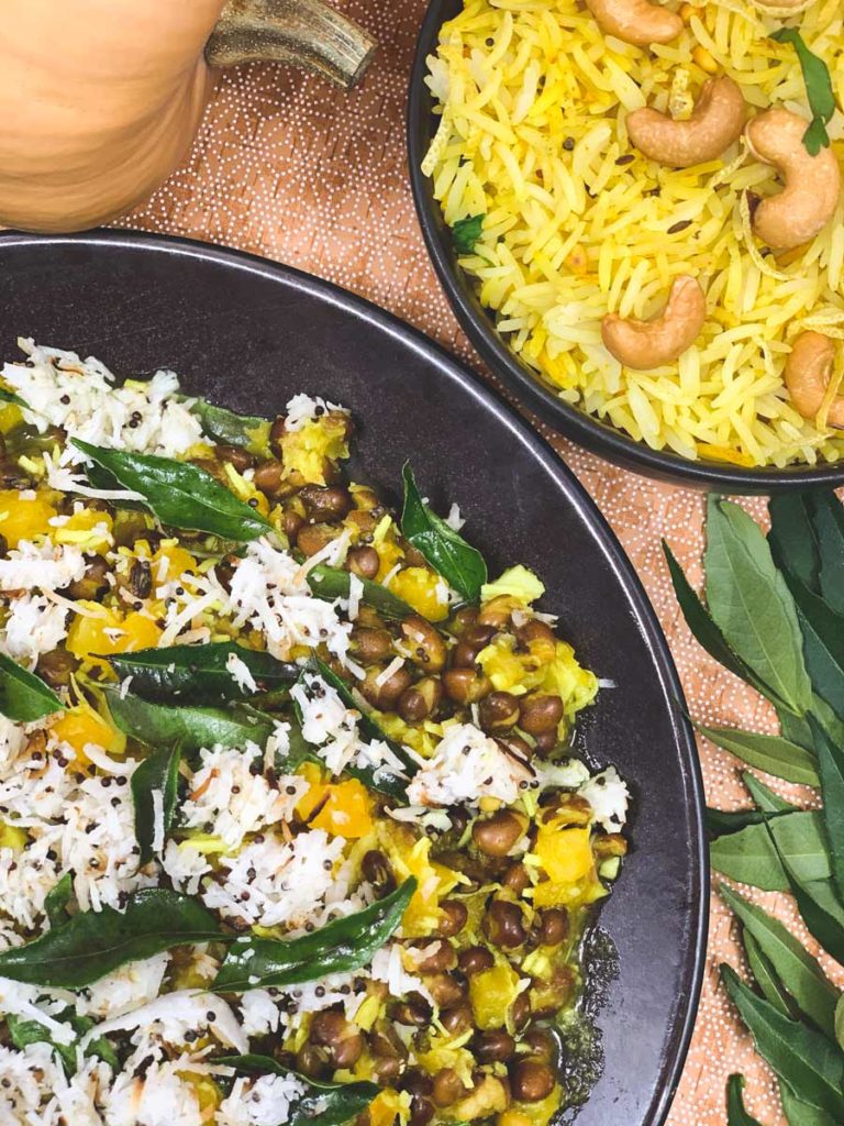 Pumpkin and Pigeon Peas with rice and curry leaves sit in a black serving bowl.