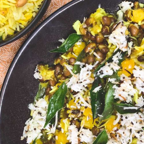 Pumpkin and Pigeon Peas with rice and curry leaves sit in a black serving bowl.