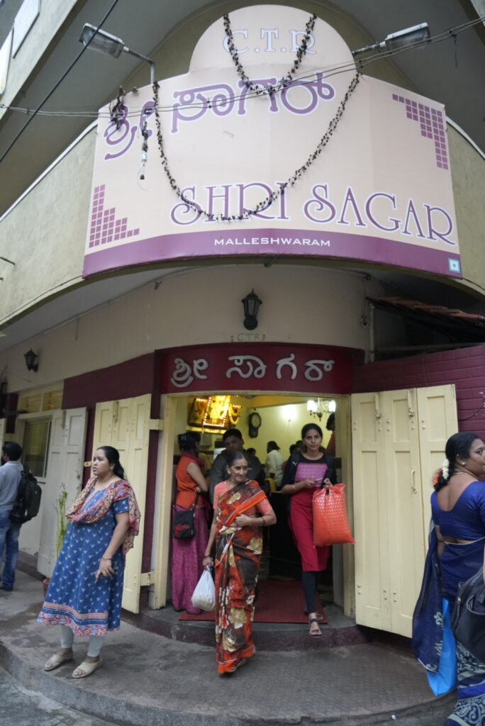 women in saris coming out of a building