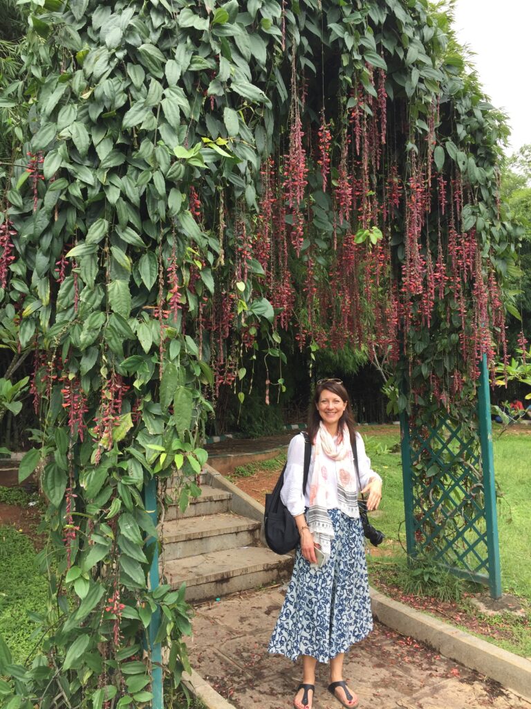 a woman in front of a trellis