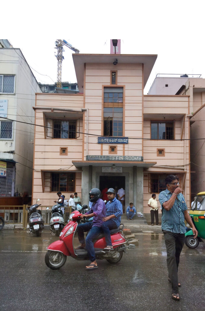 people in front of a pinkish brown building